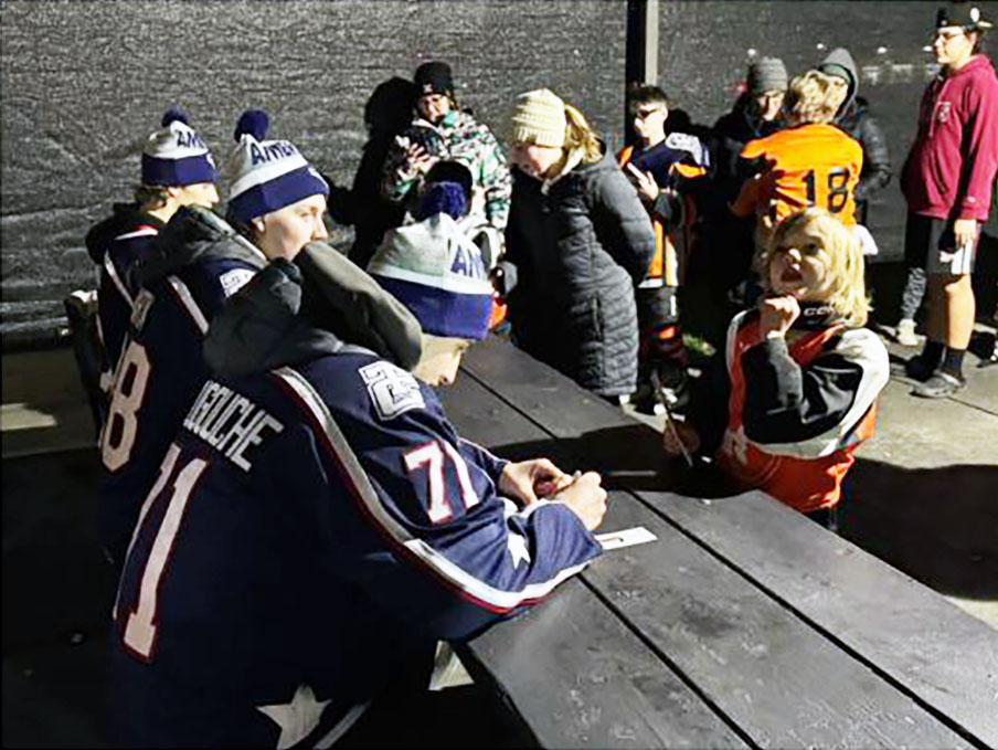 Izzy Abougouche at a table during a recent community event in Pendleton, Oregon. The Lac La Biche-born WHL player enjoys off-ice events and says he remembers when Portage College Voyageurs players would come to his minor hockey events.