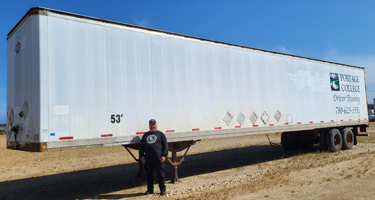 Instructor Glenn stands in front of donated trailer