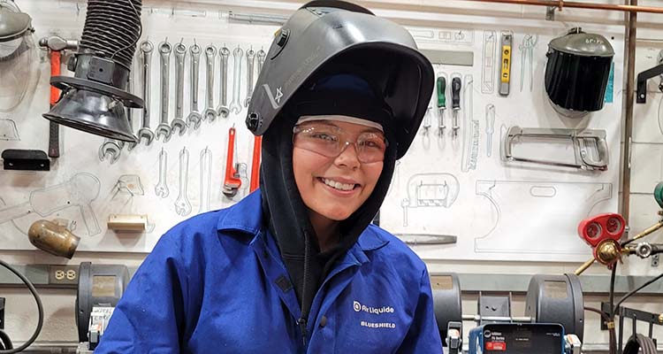 Star smiling at camera in her welding gear