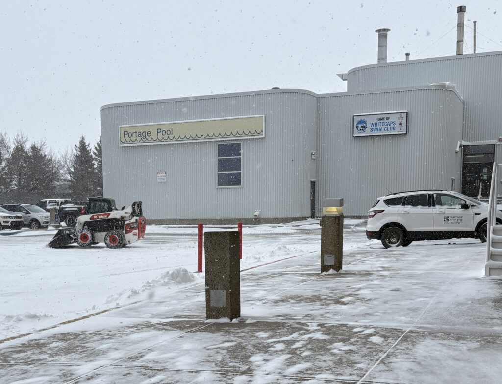 More snow? Wow - we're swimming in it. A Portage College facilities worker clears another blast of winter from the college and Portage Pool parking lot last Friday.